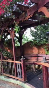 a wooden bench sitting under a wooden pergola at Hidden oasis in Mandeville