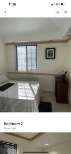 1 dormitorio con cama y ventana en Hidden oasis, en Mandeville