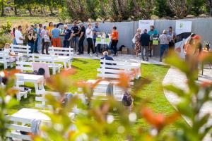 una multitud de personas de pie alrededor de las mesas en un parque en Dobosi Birtokközpont, en Szentantalfa