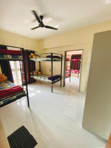 Habitación con literas y ventilador de techo. en The Peacewood's Homes - Pune's Comfort - Hostel & PG, en Pune