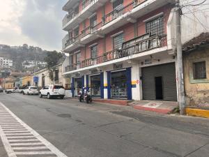克薩爾特南戈的住宿－Apartamento Central Xelajú，前方停有摩托车的街道上的建筑物