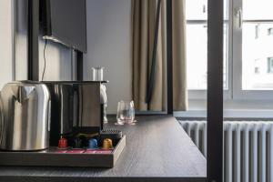 a kitchen counter with a coffee maker and a glass at Hotel Goldener Stern - contactless check-in in Luzern