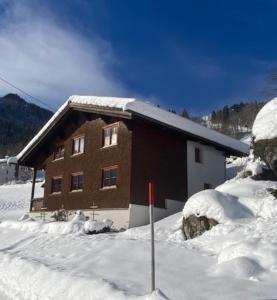 ein schneebedecktes Gebäude in der Unterkunft Walserhaus in Brand