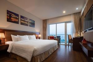 a hotel room with a bed and a large window at Gold Coast Hotel Resort & Spa in Dong Hoi