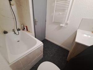 y baño con bañera blanca, aseo y lavamanos. en L'Ostal, en Carcassonne