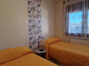 a bedroom with two twin beds and a window at La casa del patio in Zafra