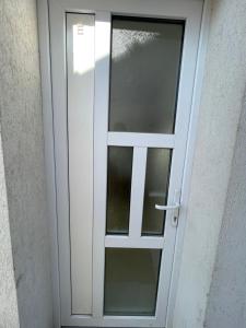 une porte blanche avec des panneaux de verre sur un bâtiment dans l'établissement Appart’ Cosy (E) proche Paris/Roissy CDG, à Tremblay-en-France