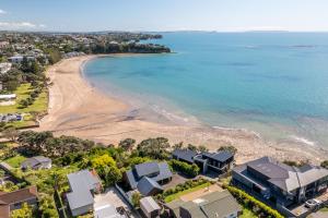 an aerial view of a beach and houses at Clifftop Coastal Retreat with Ocean Views - Close to Beach & Cafés in Auckland