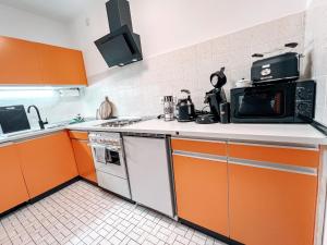 a kitchen with orange cabinets and a microwave at Neue, attraktive Wohlfühlwohnung mit traumhafter Aussicht in Neubulach