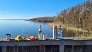 - une table avec 2 bouteilles de vin et des verres sur une clôture dans l'établissement Ferienwohnung Seestern in Steinhude, ruhig gelegen , 2 Schlafzimmer, 2 Bäder, Freies WLAN, à Wunstorf
