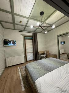 1 dormitorio con cama, mesa y TV en Apartments Mandry, en Yaremche