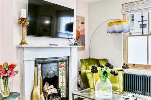 a living room with a fireplace and a green chair at Stylish, Central, North Laine, Newly Decorated in Brighton & Hove