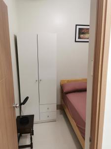 a bedroom with a bed and a cabinet and a table at Shore 3 tower 2 mall of Asia in Manila