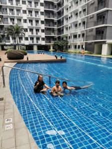 three people are sitting in a swimming pool at Shore 3 tower 2 mall of Asia in Manila