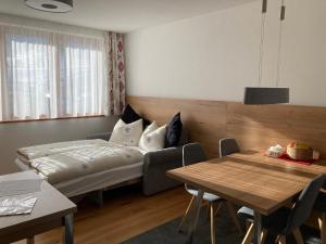a hotel room with a bed and a table at Berg Aparts Faschina Top 7 in Fontanella