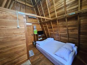 um pequeno quarto com uma cama numa parede de madeira em Luxury Wooden House 