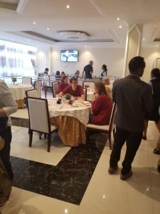 a group of people sitting at a table in a restaurant at Armah International Hotel in Āksum