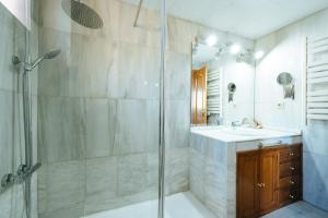 ein Bad mit einer Dusche und einem Waschbecken in der Unterkunft acogedor piso con parking santa justa in Sevilla