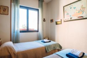 ein Krankenhauszimmer mit 2 Betten und einem Fenster in der Unterkunft acogedor piso con parking santa justa in Sevilla