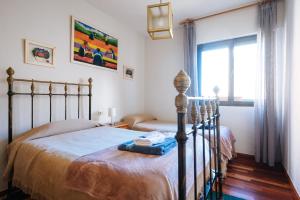 Schlafzimmer mit einem Bett und einem Fenster in der Unterkunft acogedor piso con parking santa justa in Sevilla