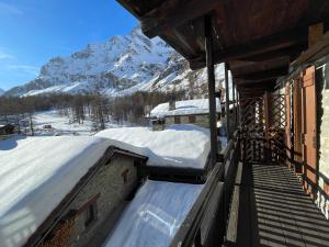 a snow covered roof of a building with a snow covered mountain at JARDIN DES ANGLAIS in Rhêmes-Notre-Dame