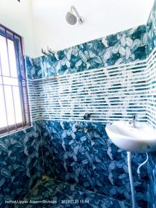 TAJ HERITAGE Hotel And Restaurant -call 94353-5O876 في جورهات: حمام مع حوض ودش ذو بلاط ازرق