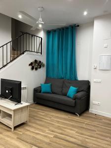 uma sala de estar com um sofá e uma televisão em Exyca Méndez Álvaro em Madri