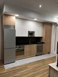 a kitchen with stainless steel appliances and wooden cabinets at Exyca Méndez Álvaro in Madrid
