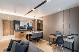 a living room with a couch and a table with a laptop at Destiny63 Ekamai Apartment in Bangkok