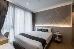 a bedroom with a large bed and a window at Destiny63 Ekamai Apartment in Bangkok