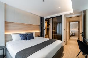 a bedroom with a large white bed with blue pillows at Destiny63 Ekamai Apartment in Bangkok