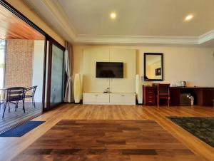 a living room with a table and a tv on the wall at Mali Kradan in Koh Kradan