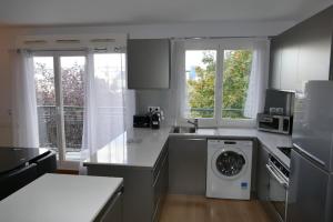 a kitchen with a washer and dryer in it at Disneyland Paris 70m² face Parc, place Ariane in Serris
