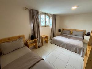 1 dormitorio con 2 camas y ventana en Riad Dar Naima Imsouane, en Imsouane