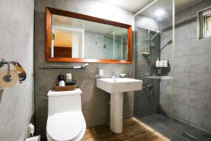 a bathroom with a toilet and a sink and a mirror at Haengok Guesthouse in Jeonju