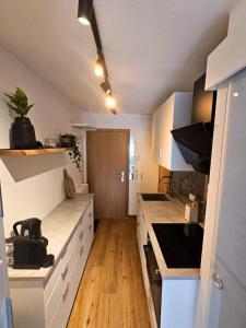 een keuken met witte aanrechtbladen en houten vloeren bij Alpen Studio Ellmau II in Ellmau