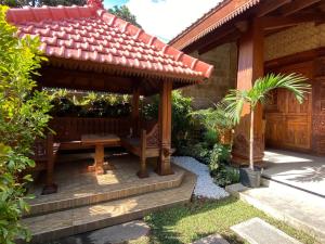 a gazebo with a bench in front of a house at ReVive by Snooze in Banyuwangi