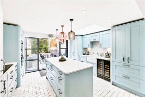 una cocina con armarios azules y encimeras blancas en Stylish, Central, North Laine, Newly Decorated, en Brighton & Hove