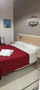 una camera da letto con un grande letto con una coperta rossa di Nautilus Hotel a La Spezia