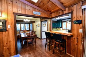 a kitchen with a bar and a dining room with wooden walls at Casa Cazadores in Arnold