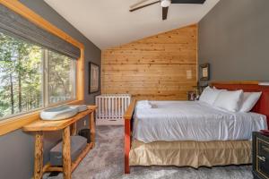 een slaapkamer met een bed, een bureau en een raam bij Hiawatha Hideaway in Camp Connell