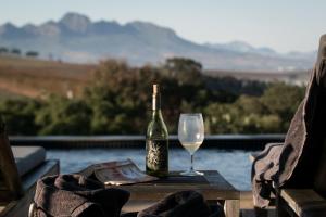 eine Flasche Wein und ein Glas auf dem Tisch in der Unterkunft Sugarbird Manor in Stellenbosch