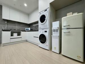 una cucina con lavatrice, asciugatrice e frigorifero di Eunhasu D&M Residence Cheongcho 3 a Daejeon