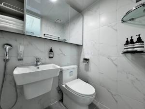 a white bathroom with a toilet and a sink at Eunhasu D&M Residence Cheongcho 3 in Daejeon