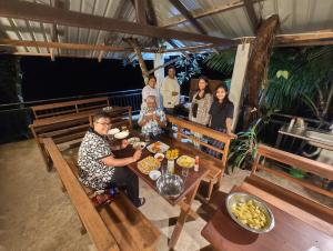 um grupo de pessoas sentadas à mesa com comida em White Villa Kitulgala em Kitulgala