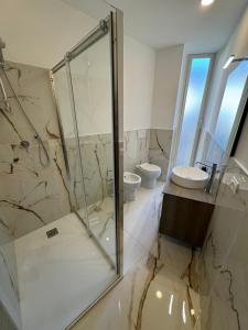 łazienka z przeszkloną kabiną prysznicową i umywalką w obiekcie Rome Luxury House - The House w Rzymie +25 zdjęć