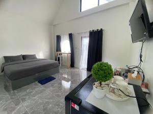 a bedroom with a bed and a table with a tv at โฮมสเตย์ สุขสำราญ รีสอร์ท in Ban Don Kha