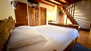 a bedroom with a large white bed in a room at Gîte rural Le Péché Mignon in Lignol-le-Château