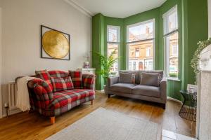 sala de estar con sofá y silla en Loving Victorian Home For Your Belfast Escape!, en Belfast