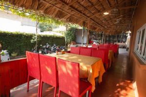 a restaurant with a table and red chairs at Cat Ba Mountain View Homestay in Cat Ba